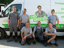 Foto von Angestellten vor einem Transporter mit der Aufschrift Die Abdichter